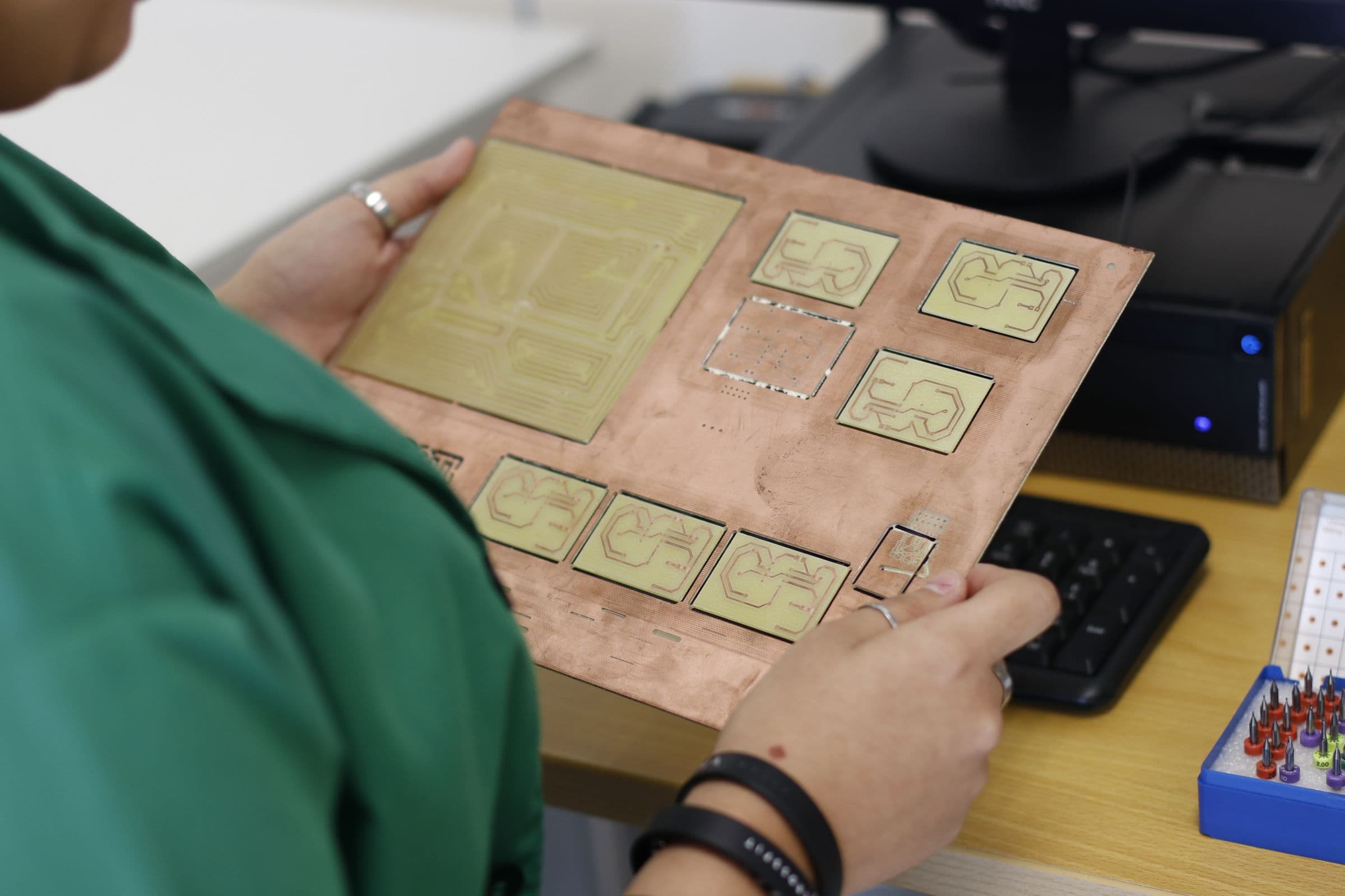 A technician inspecting a printed circuit board.