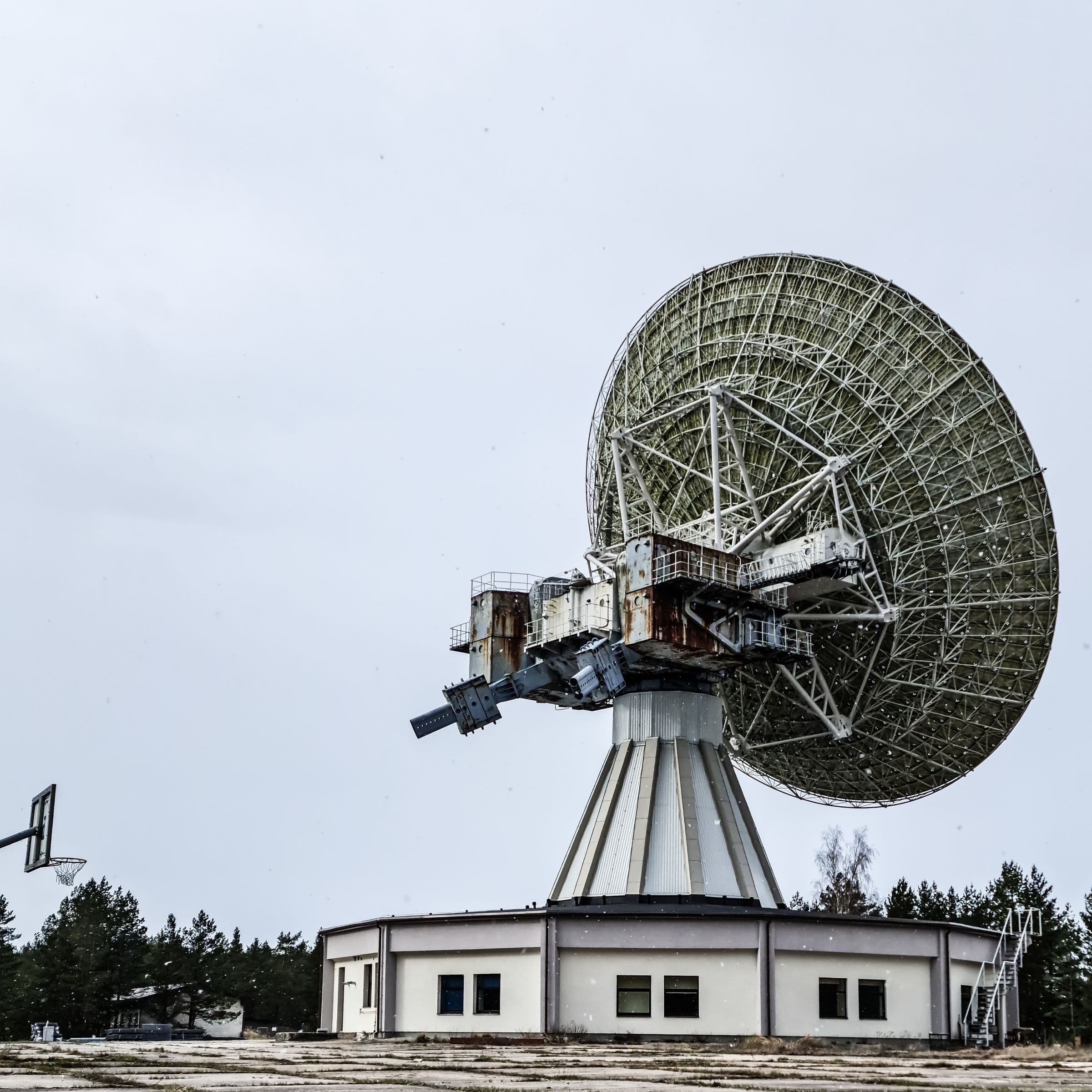 A large communications dish above a building.