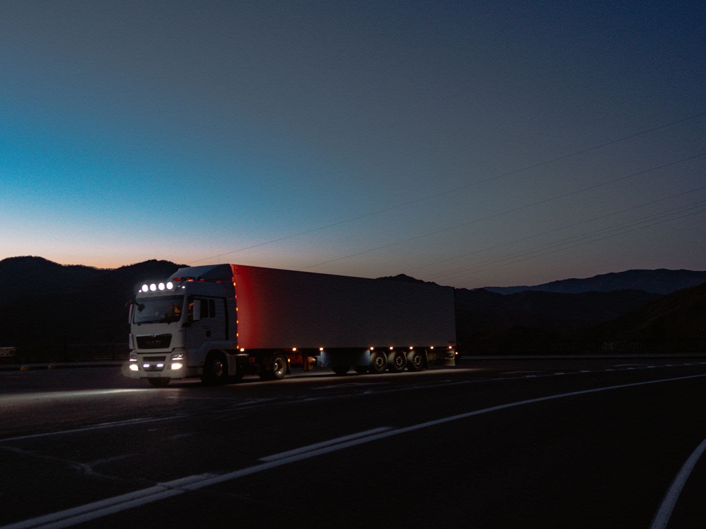 A truck on a road at dusk.