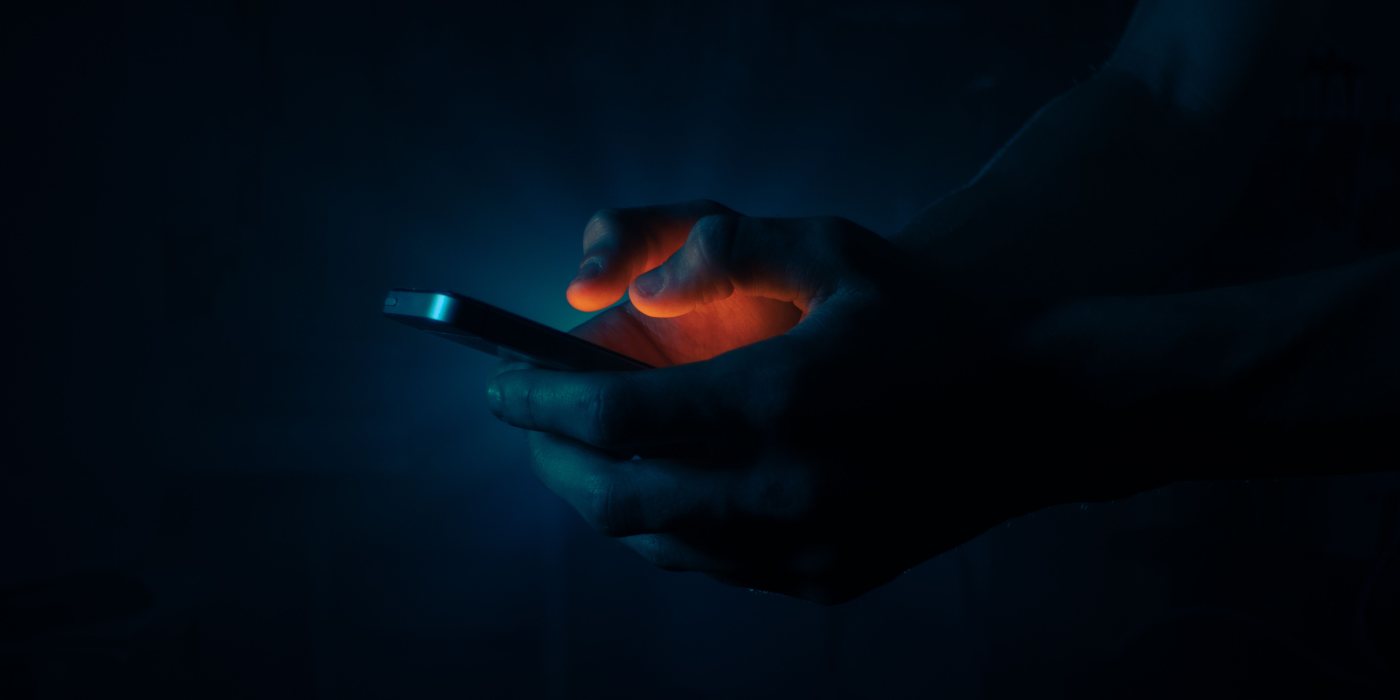 A person holding a phone in the dark.