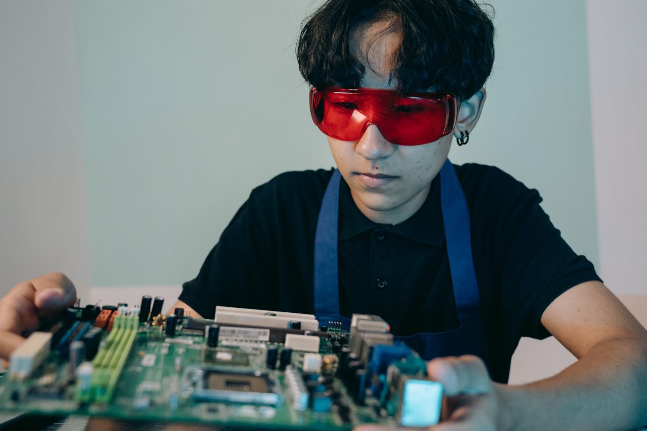 An engineer inspecting or repairing a circuit board.