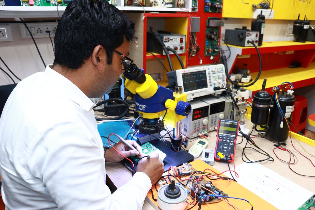 An engineer inspecting a circuit board under a microscope.